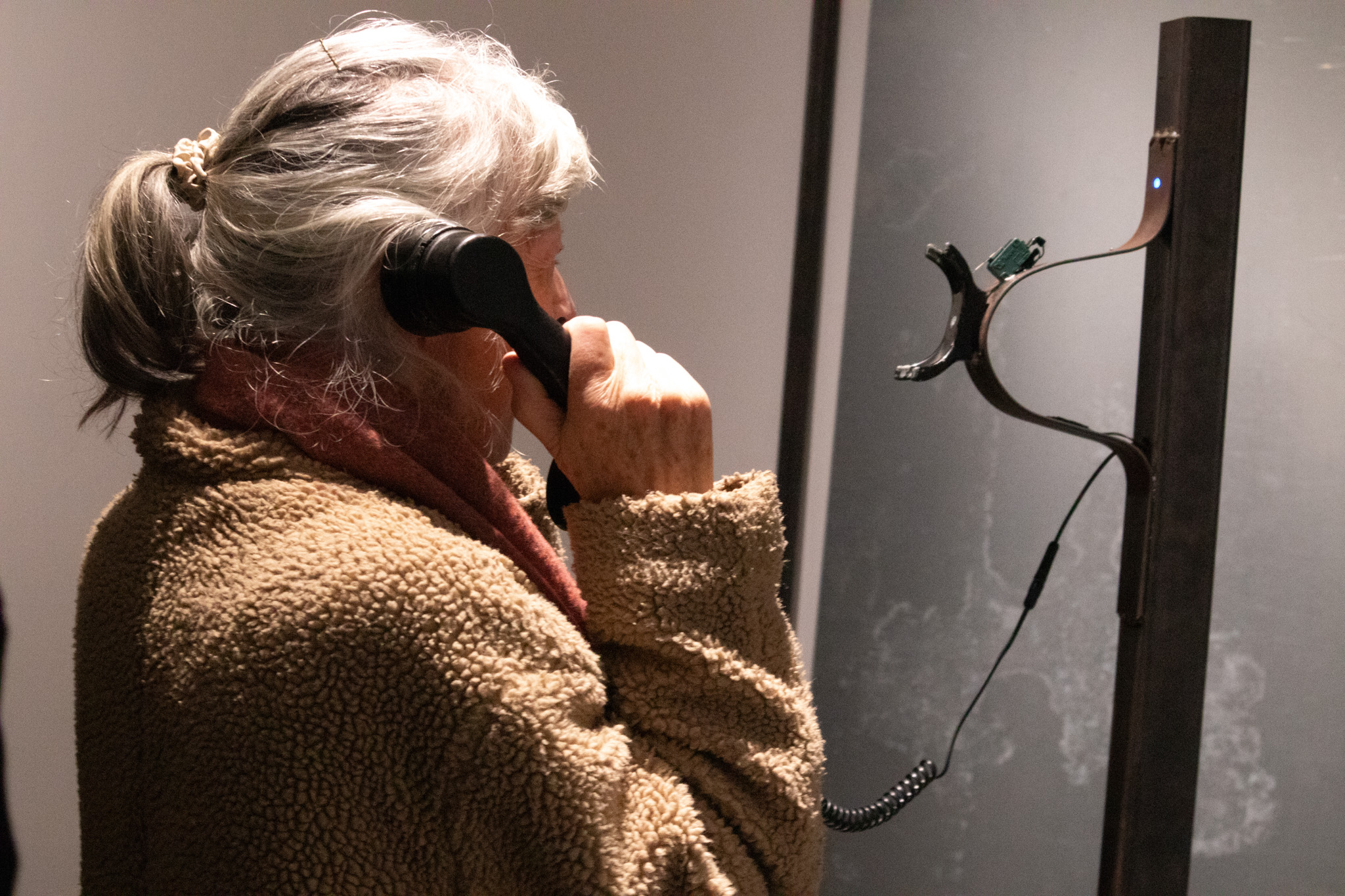 Phone on a metal pole with a red light ontop of it